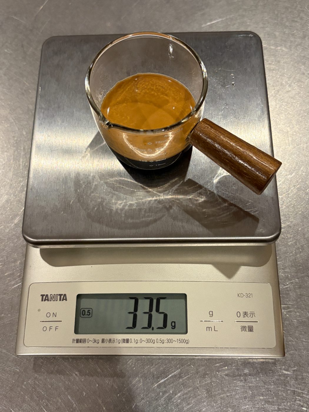 スケールにのせた計量カップのエスプレッソ。表示は33.5g