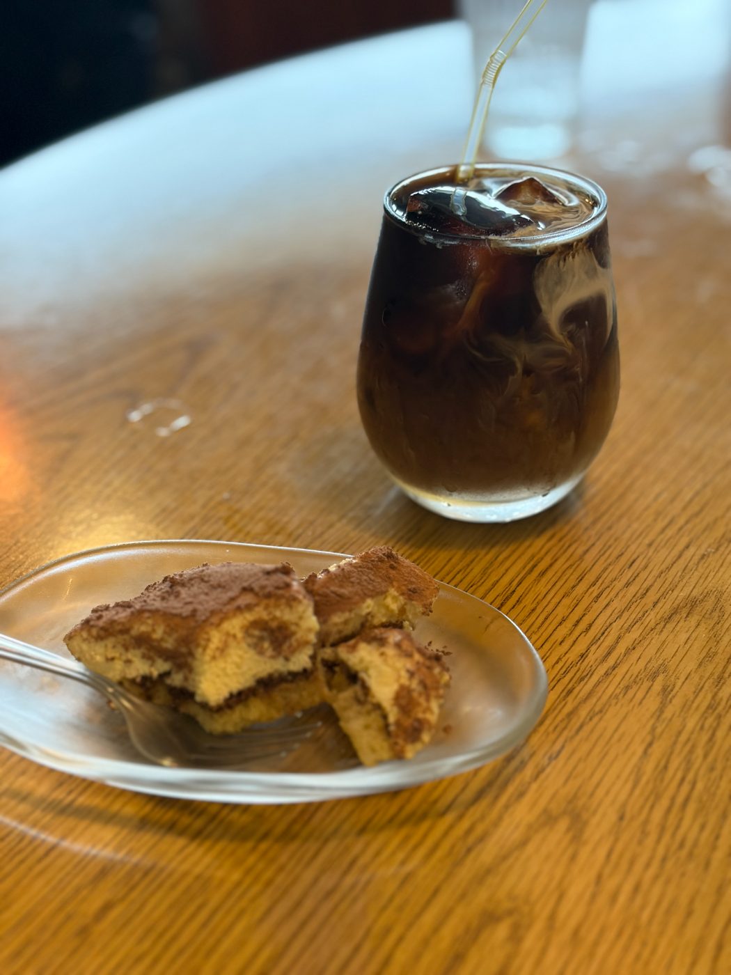 ガラスの小皿にのったティラミスと、氷の入ったアイスコーヒー