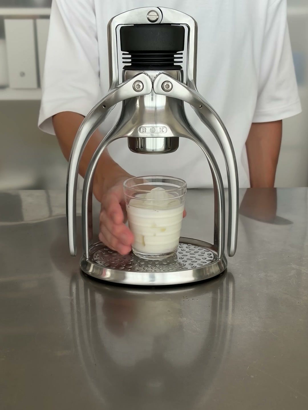 氷とミルクを入れたグラスをROK EspressoGCに置く様子
