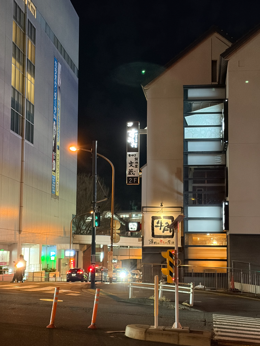 夜の街に光るやきとり家すみれの看板