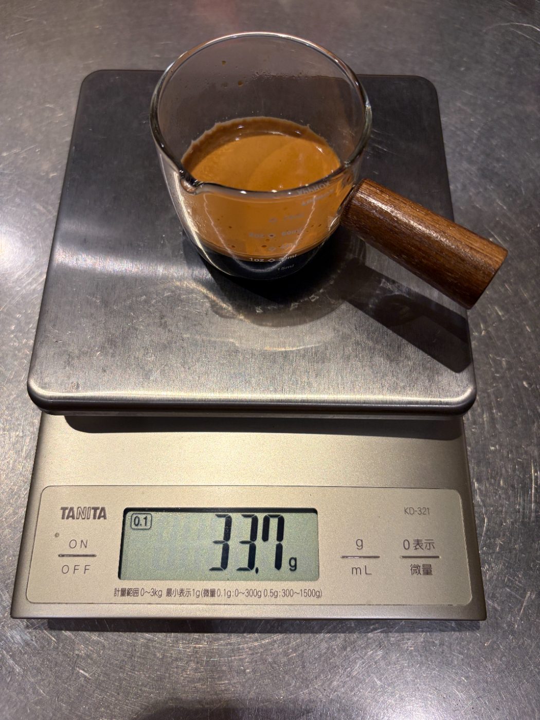 スケールにのせた計量カップとエスプレッソ。表示は33.7g