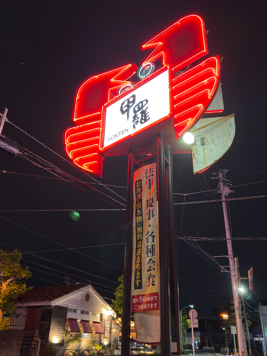 甲羅本店の赤いネオン看板