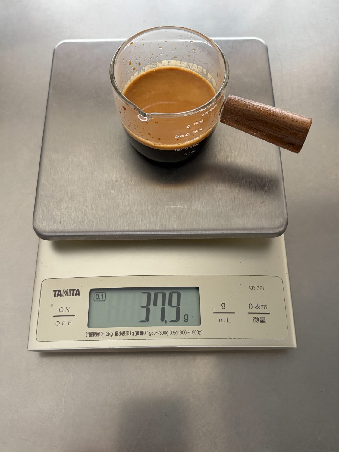 スケールにのせた計量カップとエスプレッソ。表示は37.9g