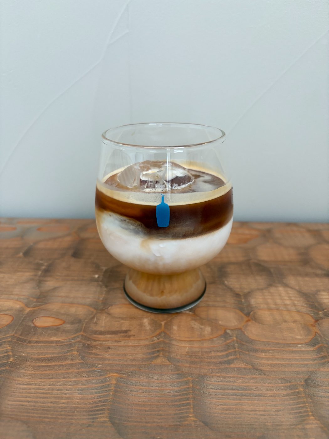 ブルーボトルコーヒーのグラスの中で、牛乳とエスプレッソが二層に分かれているアイスカフェラテ