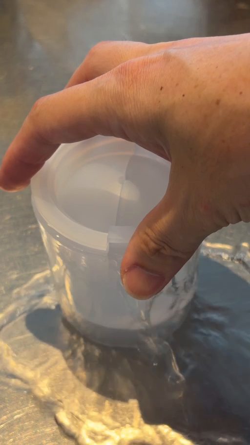 中容器を押し込んで、外容器から水があふれている
