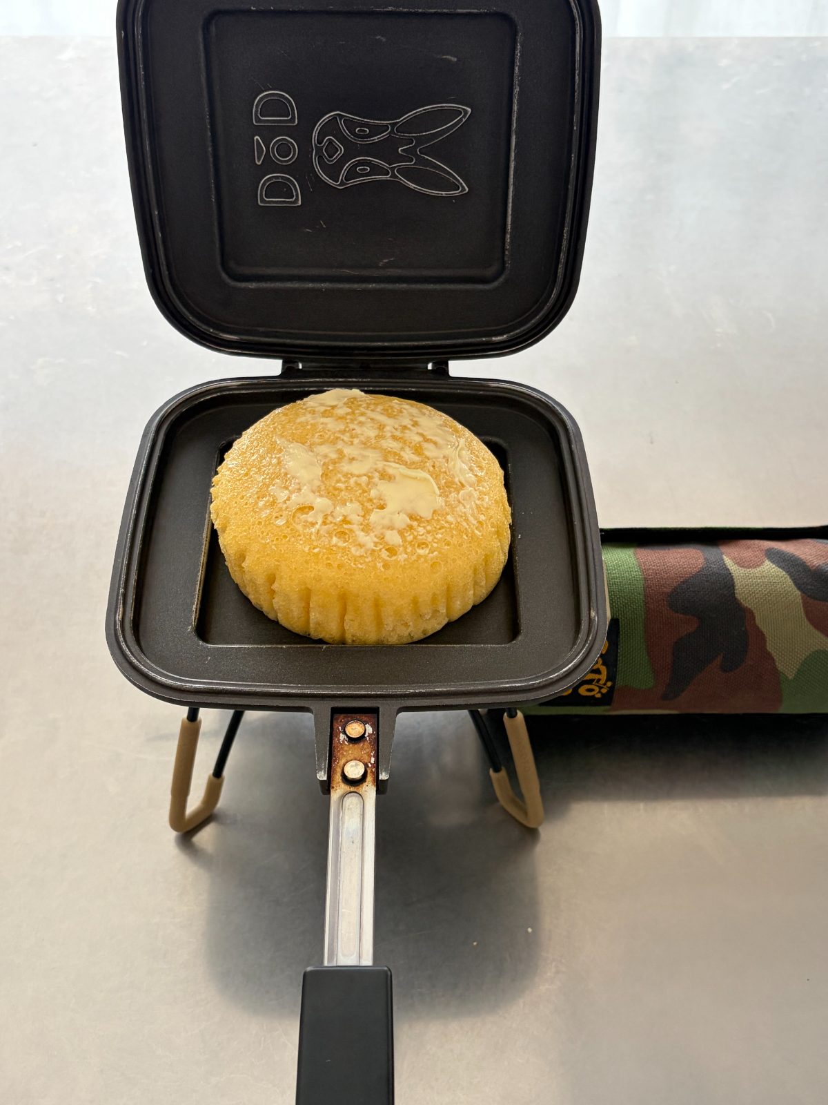 バターを塗ったジャンボむしケーキをDODのうさサンドメーカーで焼く様子