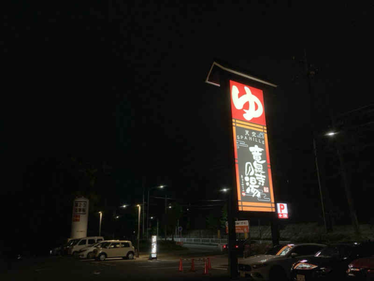 駐車場から見上げた竜泉寺の湯の看板