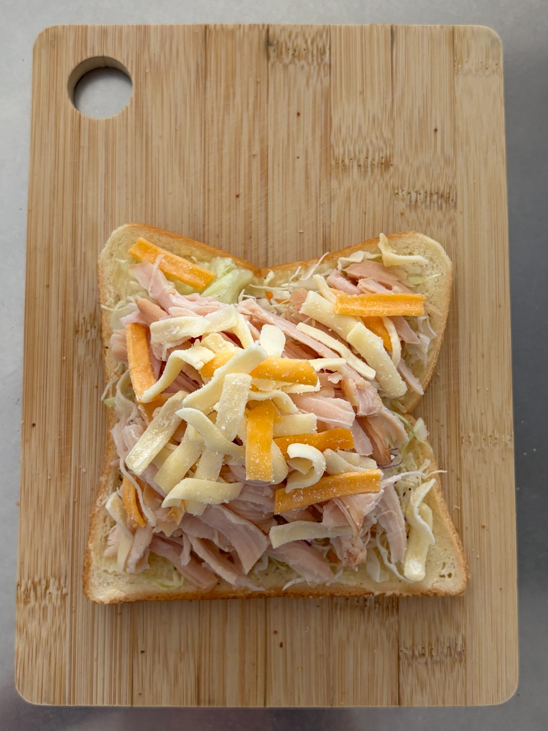 サラダチキンの上にとろけるチーズをのせたところ