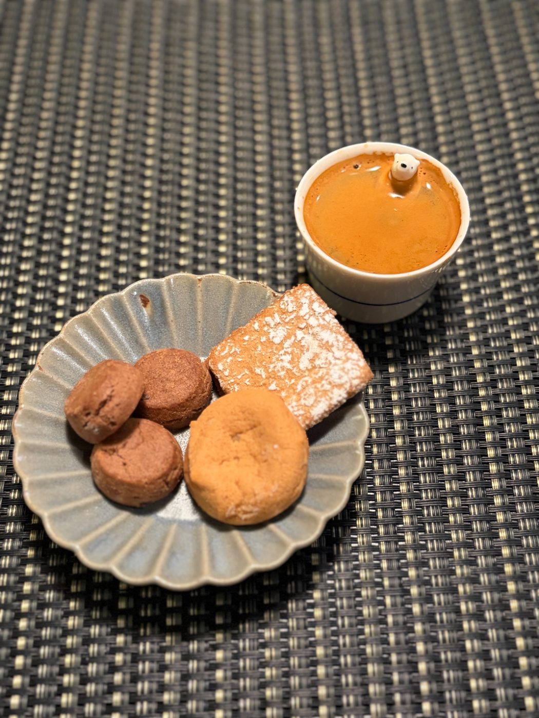 エスプレッソから顔だけ出したシロクマのおちょこと、輪花の皿にのせたクッキー